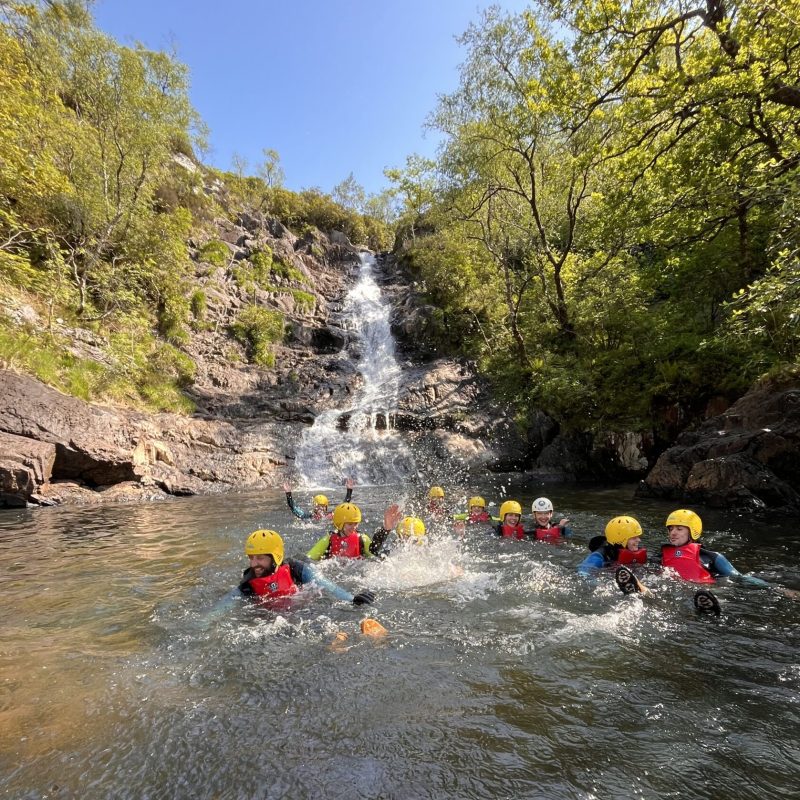 a group of people riding on the back of a boat in the water