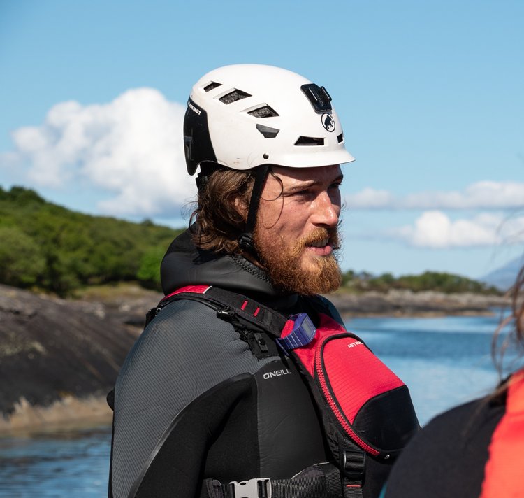a man standing next to a body of water